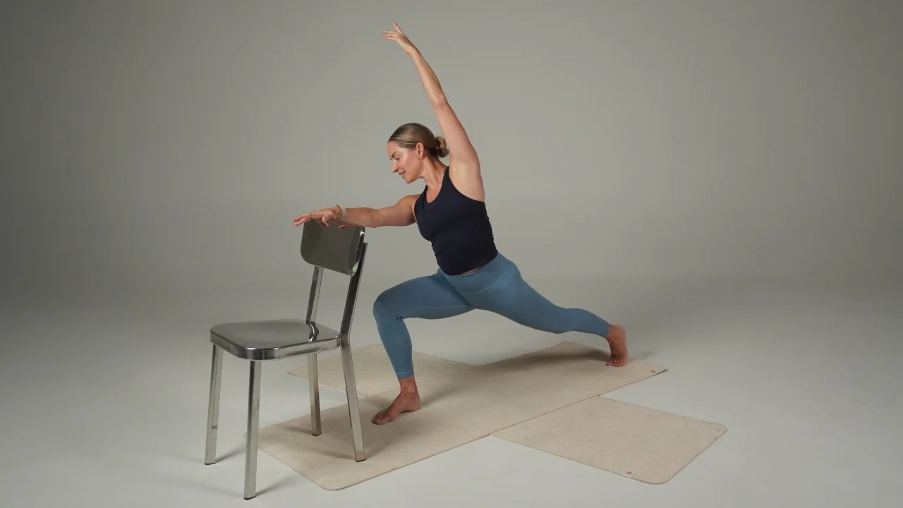 Chrissy practising Awaken Barre with a chair