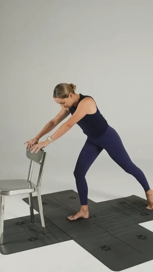 Chrissy Sundt holding the back of a chair, one leg extended behind her